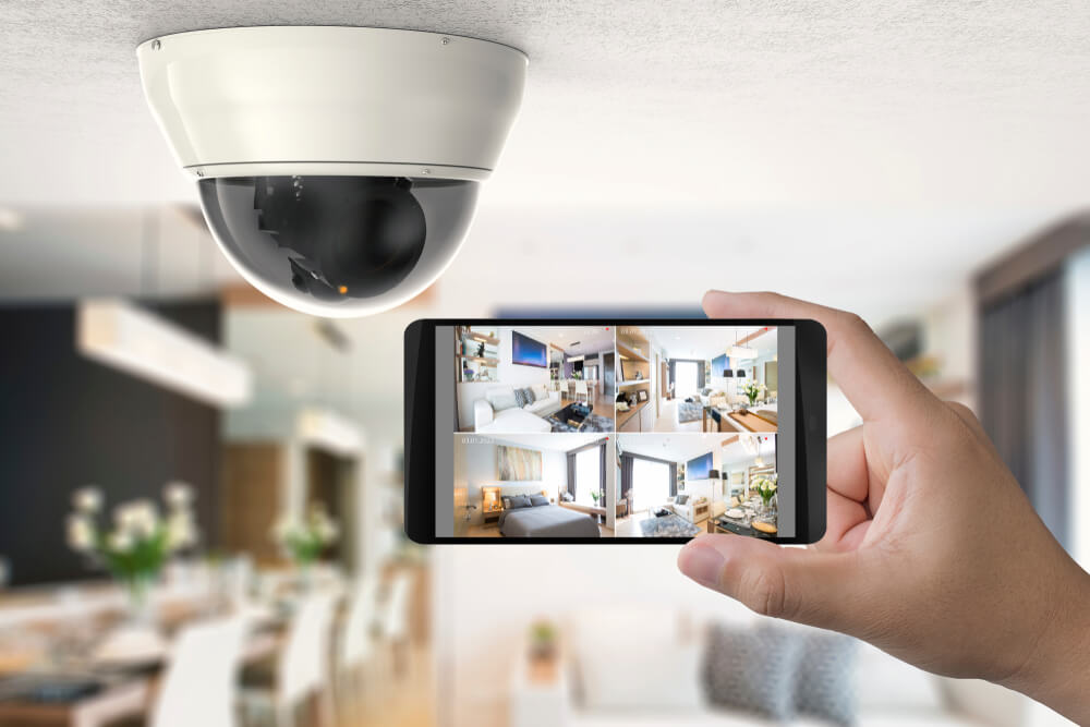 Security camera and smartphone showing live home CCTV feeds